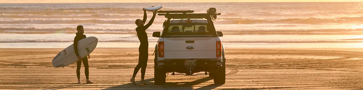 Surfing on the shore A lakeshore scene featuring a couple loading paddleboards on their car.