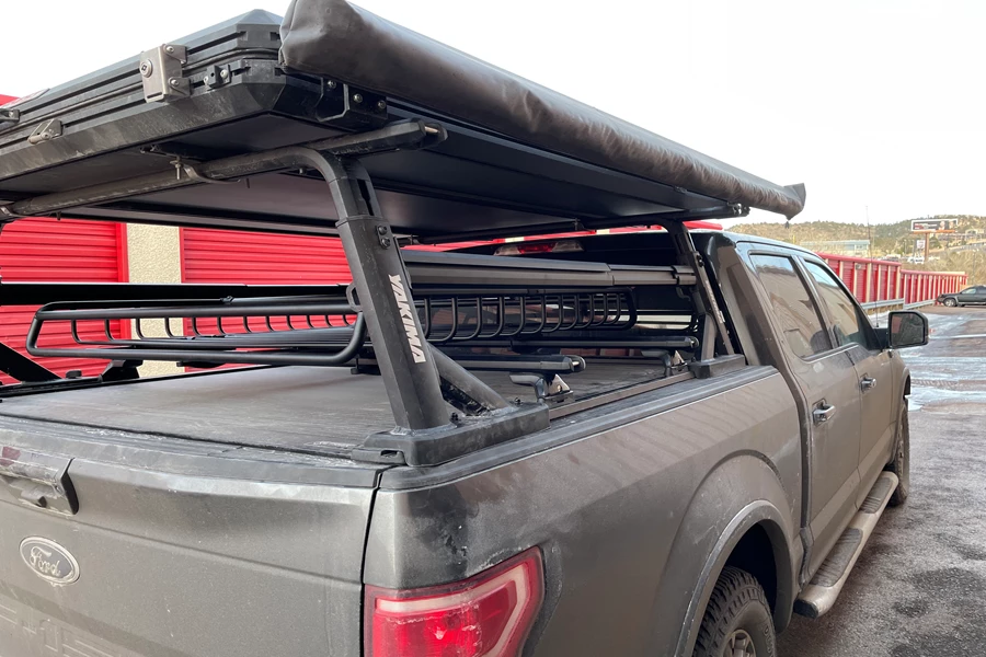This Ford F-150 is RACKED OUT with a ReTrax XR tonneau cover, a Yakima OverHaul HD truck rack, awning, roof-top tent, Yakima SideBar, and a low profile Yakima SkyLine base rack system with a MegaWarrior cargo basket in between.